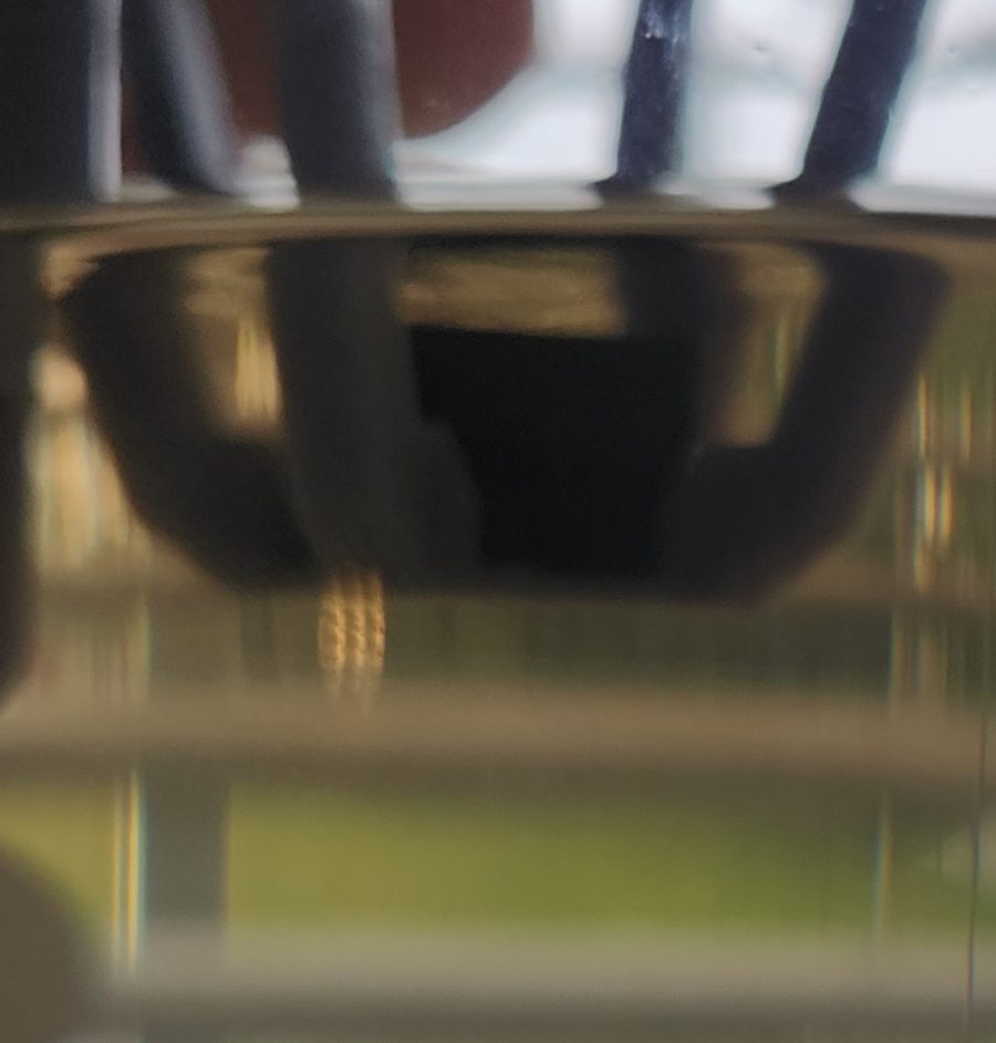 Beaker with a brown colloid in front of a metal target