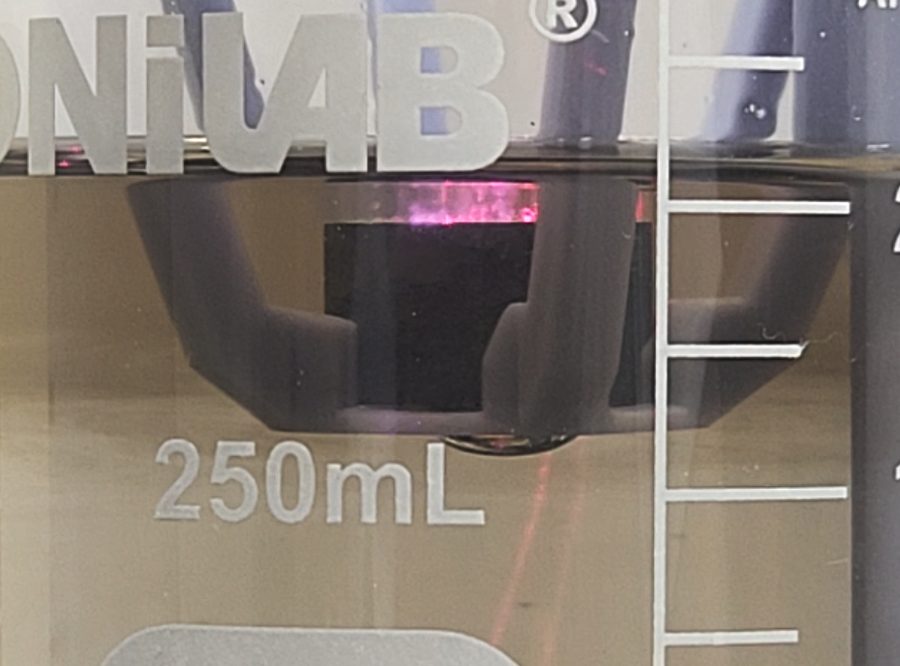 Metal target in a beaker lit by a magenta laser